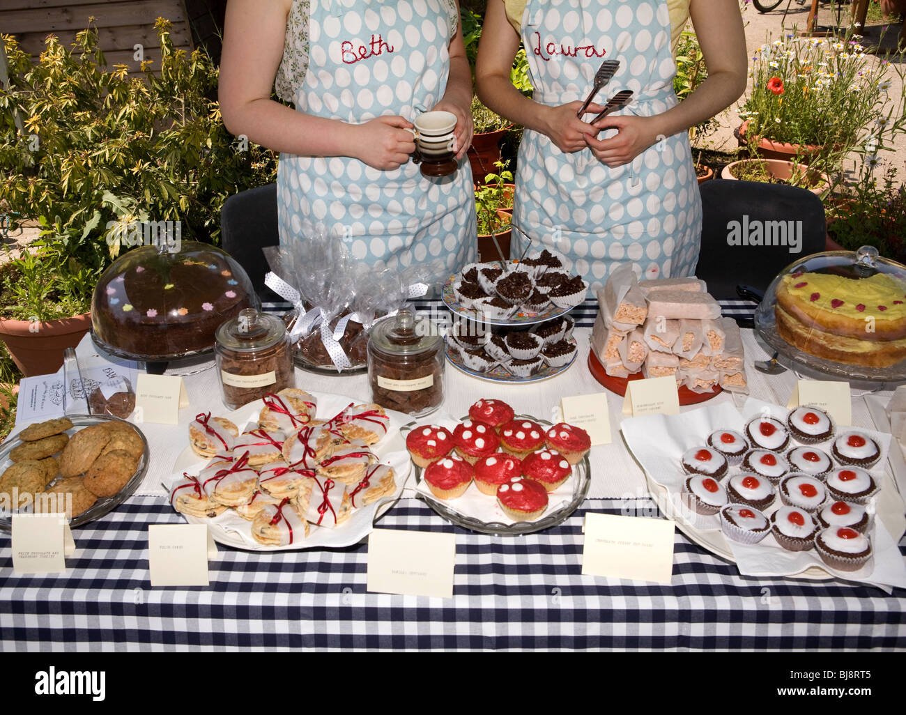 Due donne vendendo torte e biscotti a un mercato di stand Foto Stock