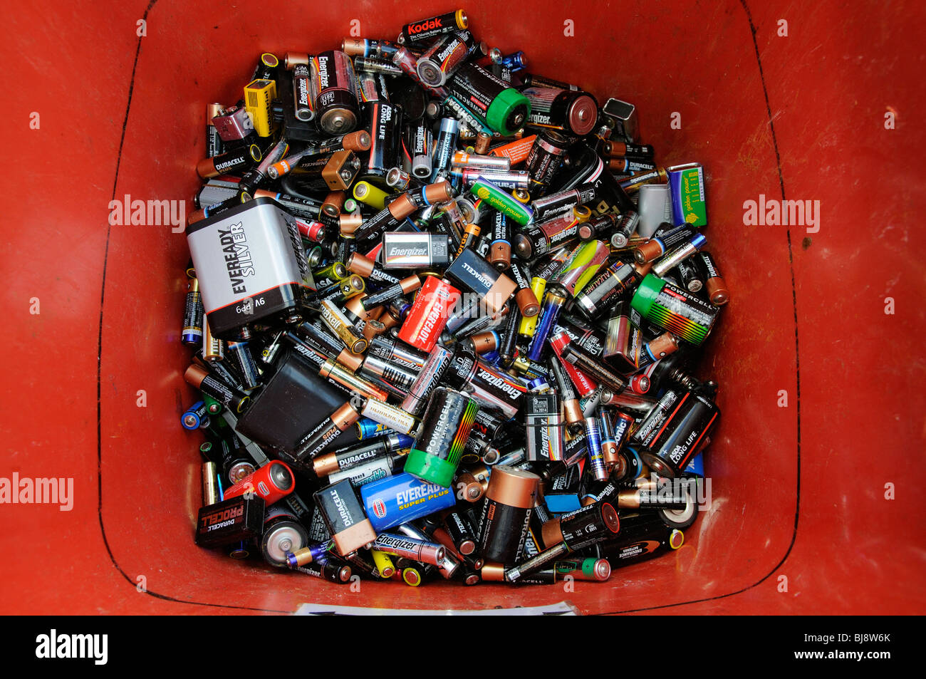 Batterie per uso domestico attendono la raccolta e il riciclaggio in questo scomparto di rosso Foto Stock