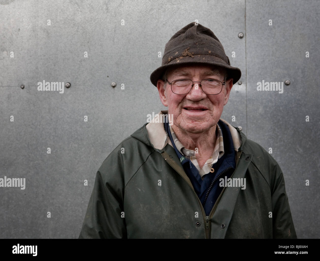 Ritratto di senior agricoltore nella parte anteriore del foglio metallico sparso Foto Stock