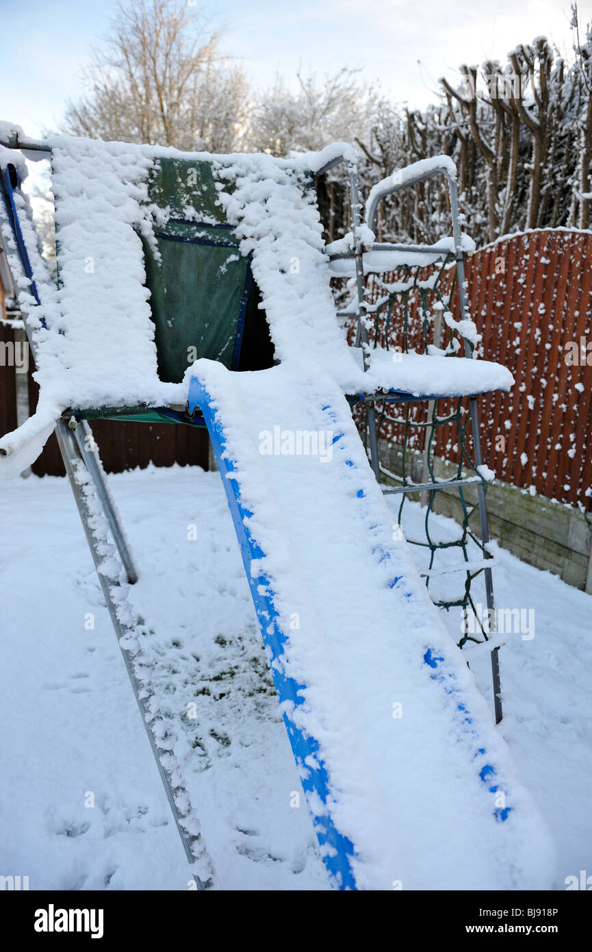 Gioco del bambino slitta ricoperto di neve in inverno Foto Stock