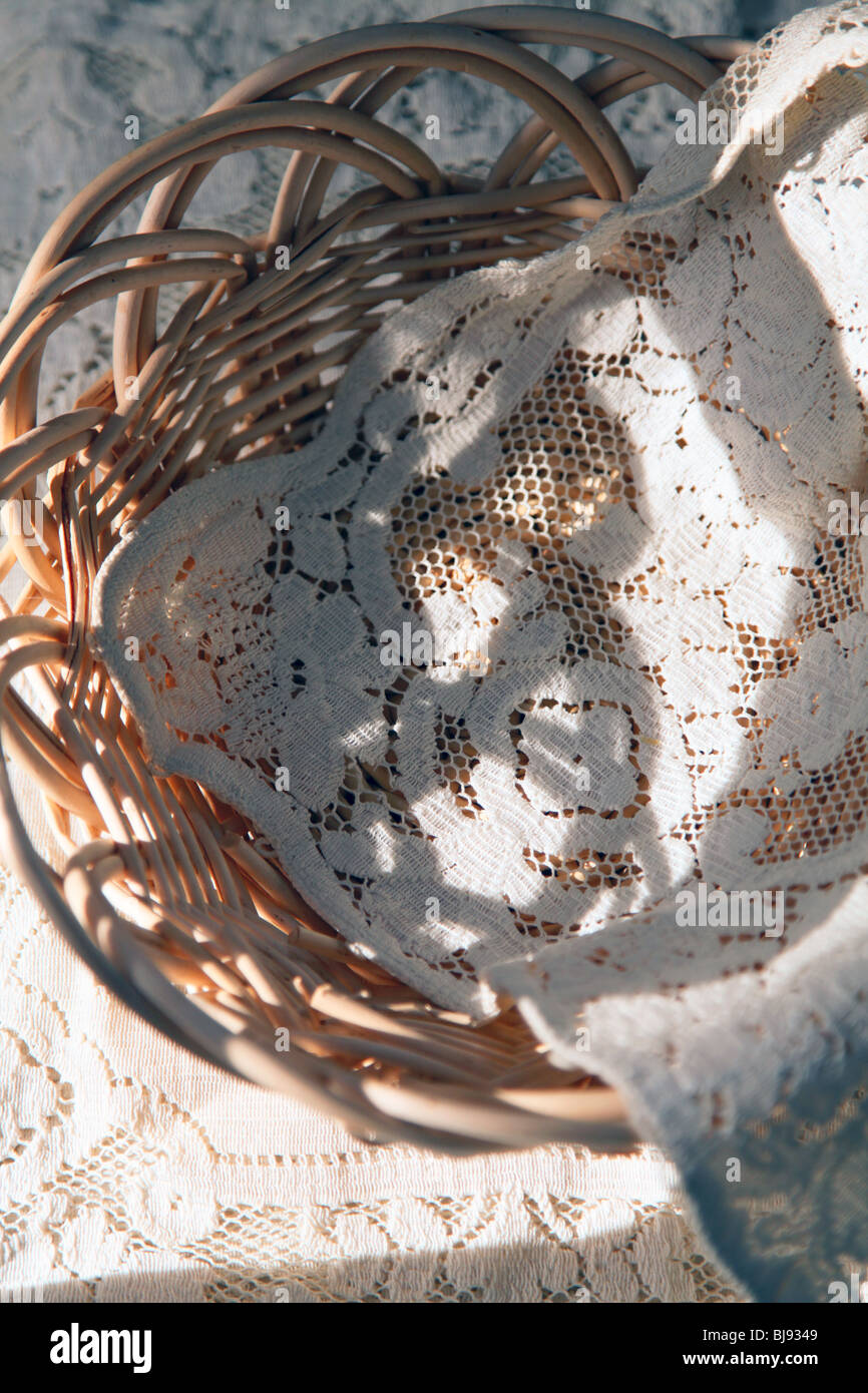 Mano cesto tessuto & antique Pizzo sono una bella vista in inizio di mattina di sole creando le forme insolite e drammatico artistico ombra Foto Stock