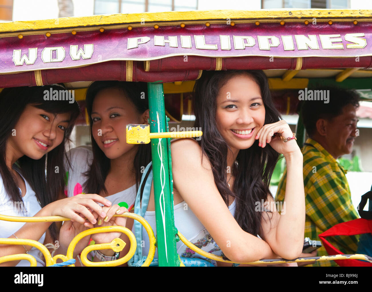 Tre ragazze filippini a cavallo e carrozza turistica; Intramuros; Manila Filippine; Foto Stock