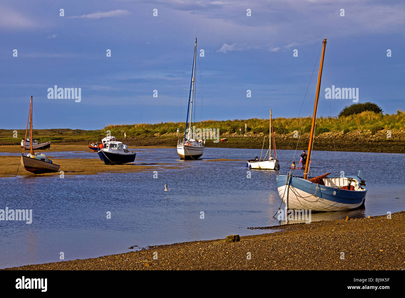 Barche a bassa marea nel porto naturale a Overy Staithe Norfolk Foto Stock