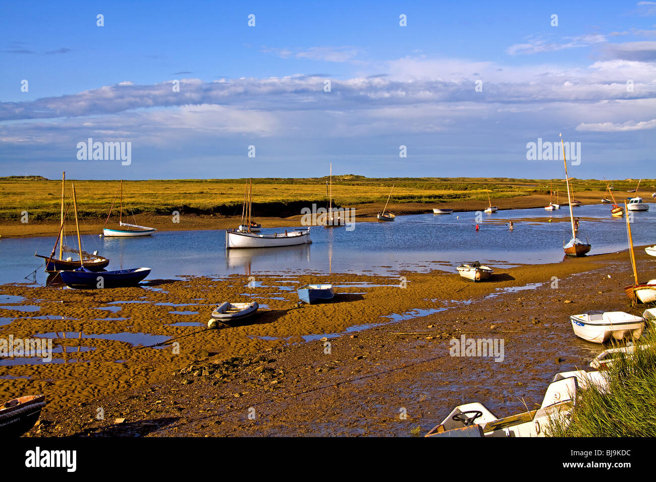 Barche a bassa marea nel porto naturale a Burnham Overy Staithe Norfolk Foto Stock