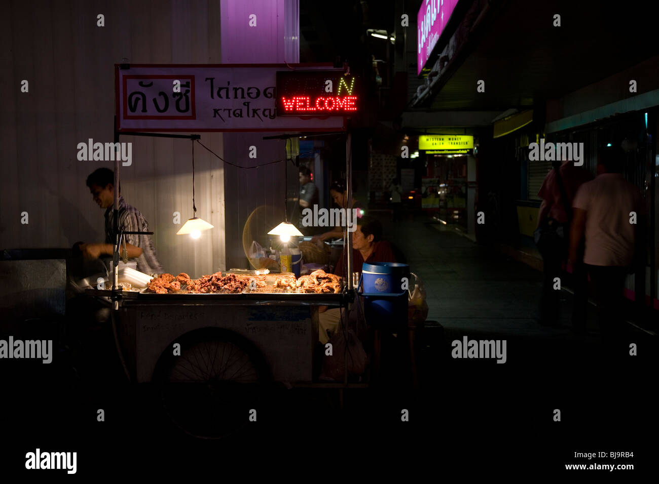 Sul lato della strada venditore a vendere cibo durante la notte a Bangkok Foto Stock