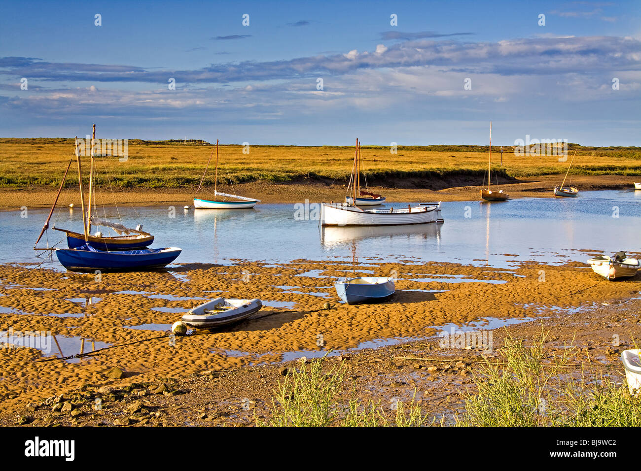 Barche a bassa marea nel porto naturale a Overy Staithe Norfolk Foto Stock