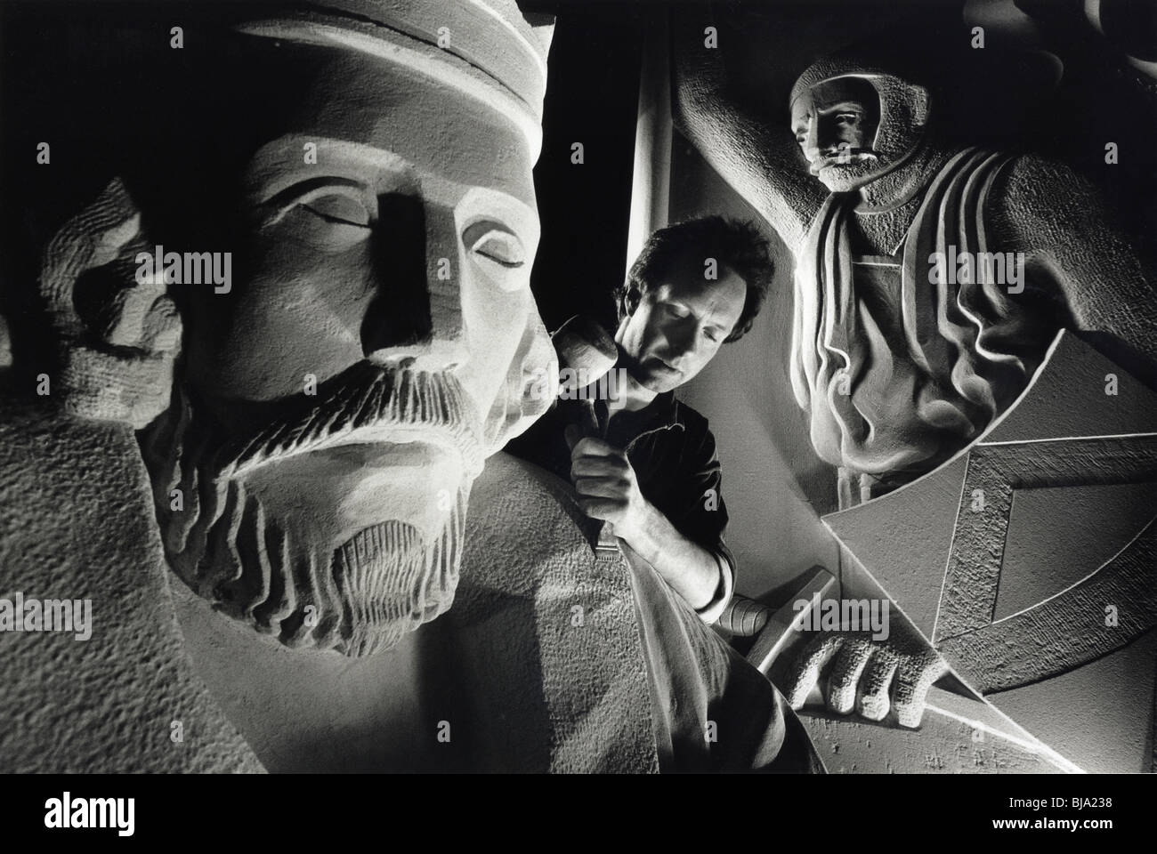 Un scalpellino lavorando su una statua di Re Giovanni in un workshop di Londra che ripristina i monumenti storici. Foto Stock