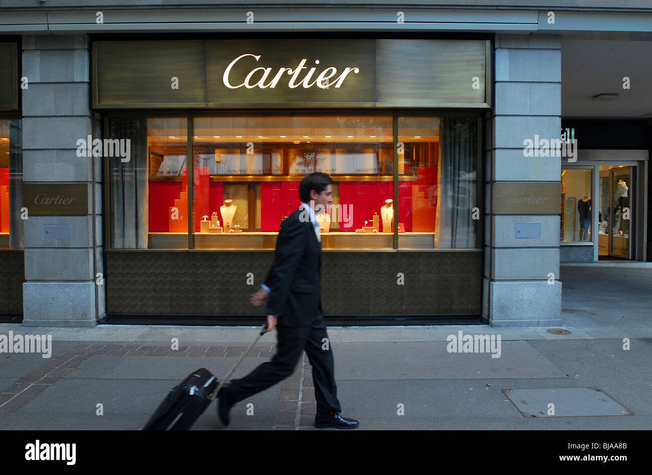 Un uomo che passa da una finestra di visualizzazione di un Cartier gioielleria, Zurigo, Svizzera Foto Stock
