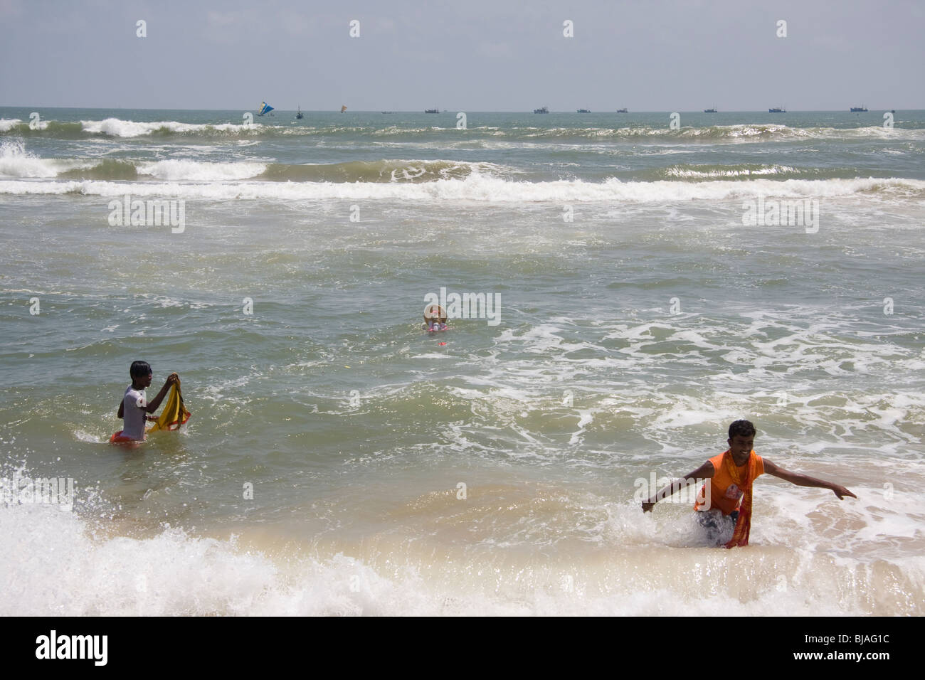 Due giovani uomini di ritorno dal surf dopo immersione di una statua del dio elefantino Ganesh nel surf durante Ganpati a Puri, Orissa. Foto Stock