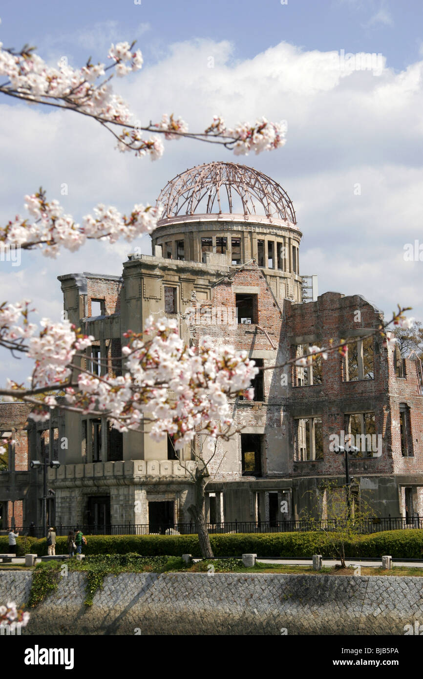 La cupola della bomba di Hiroshima, Giappone con la fioritura dei ciliegi in primo piano Foto Stock