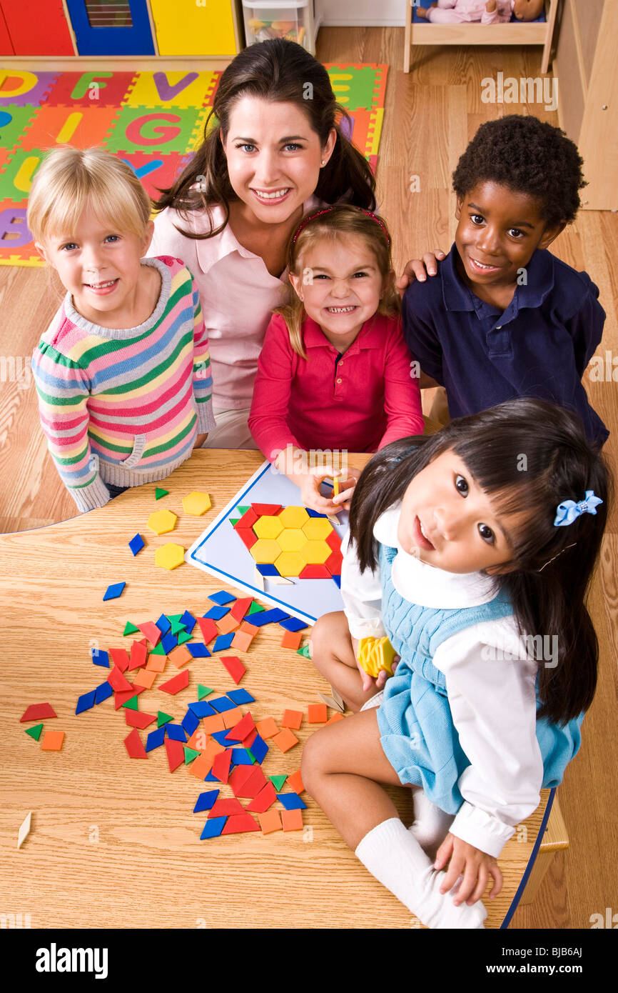 Gruppo di bambini con insegnante in età prescolare forme di apprendimento Foto Stock