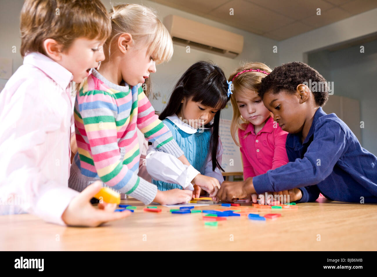 Bambini in età prescolare lavorando insieme su puzzle Foto Stock