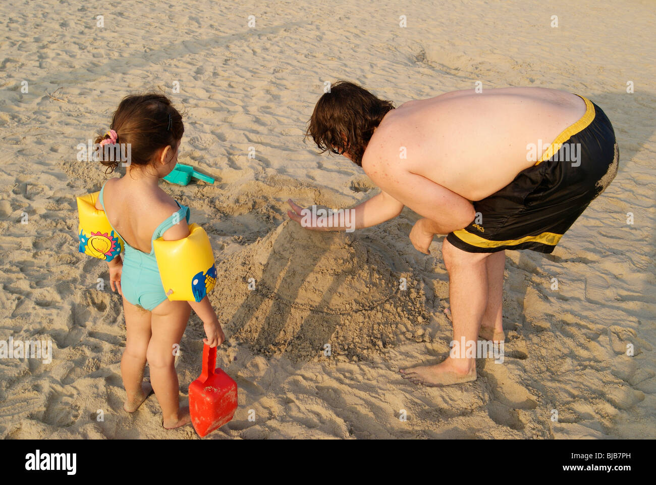 Carina ragazza turistica con suo padre la costruzione di un bel palazzo in riva mare sand.padre e figlia giocando a Kovalam Beach India Foto Stock