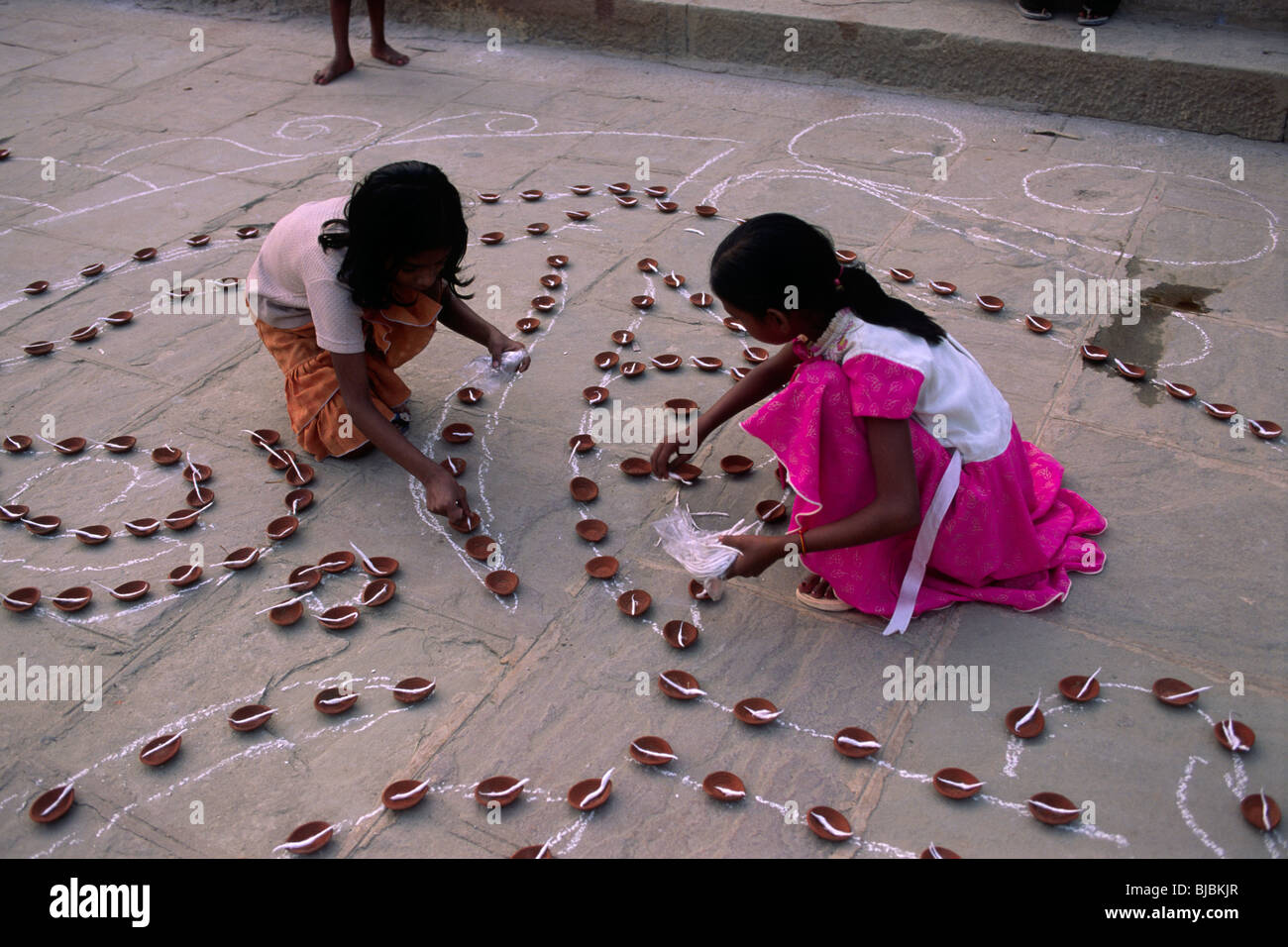 India, Varanasi, fiume Gange, festival Kartik Purnima, bambini che preparano candele Foto Stock