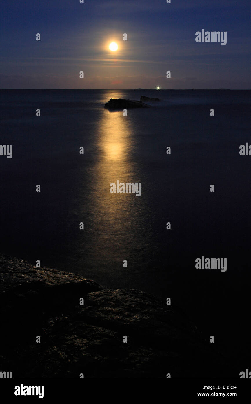 Luna piena, che si eleva al di sopra del Mare del Nord, Northumberland, Inghilterra Foto Stock