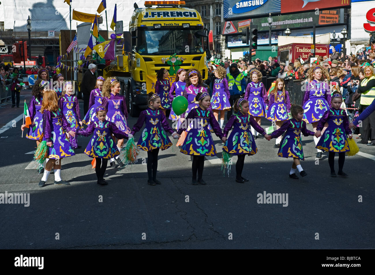 Un gruppo di giovani femmine ballerini irlandesi di eseguire durante la Festa di San Patrizio processione in Londra. Foto Stock