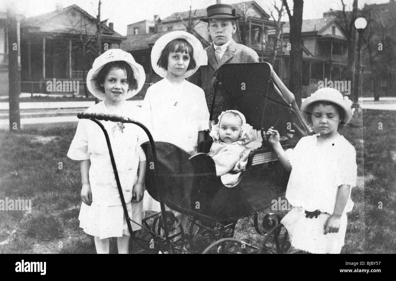 Gruppo di bambini con il bambino nel passeggino, Cairo, Illinois nel 1900s. Xx secolo la famiglia midwest case di legno quartiere Foto Stock