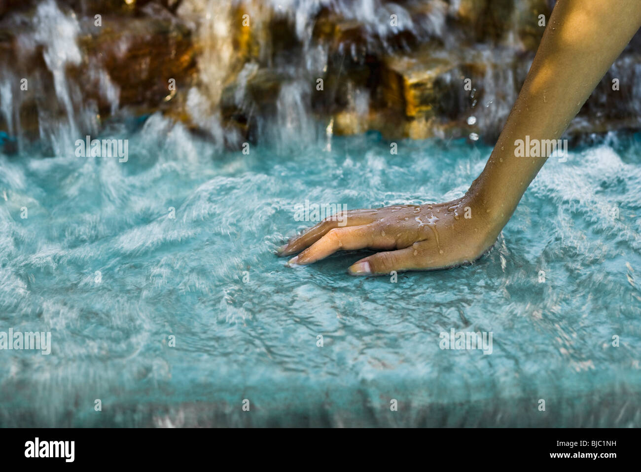 L'acqua che scorre dalla cascata di oltre donna di mano Foto Stock