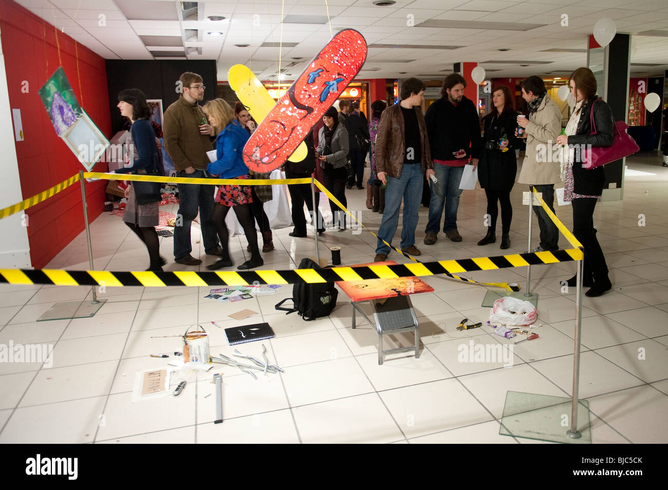 Le persone in cerca di art in una temporanea una notte sola specifica per il sito di installazione galleria espositiva in un vuoto di shop store, REGNO UNITO Foto Stock