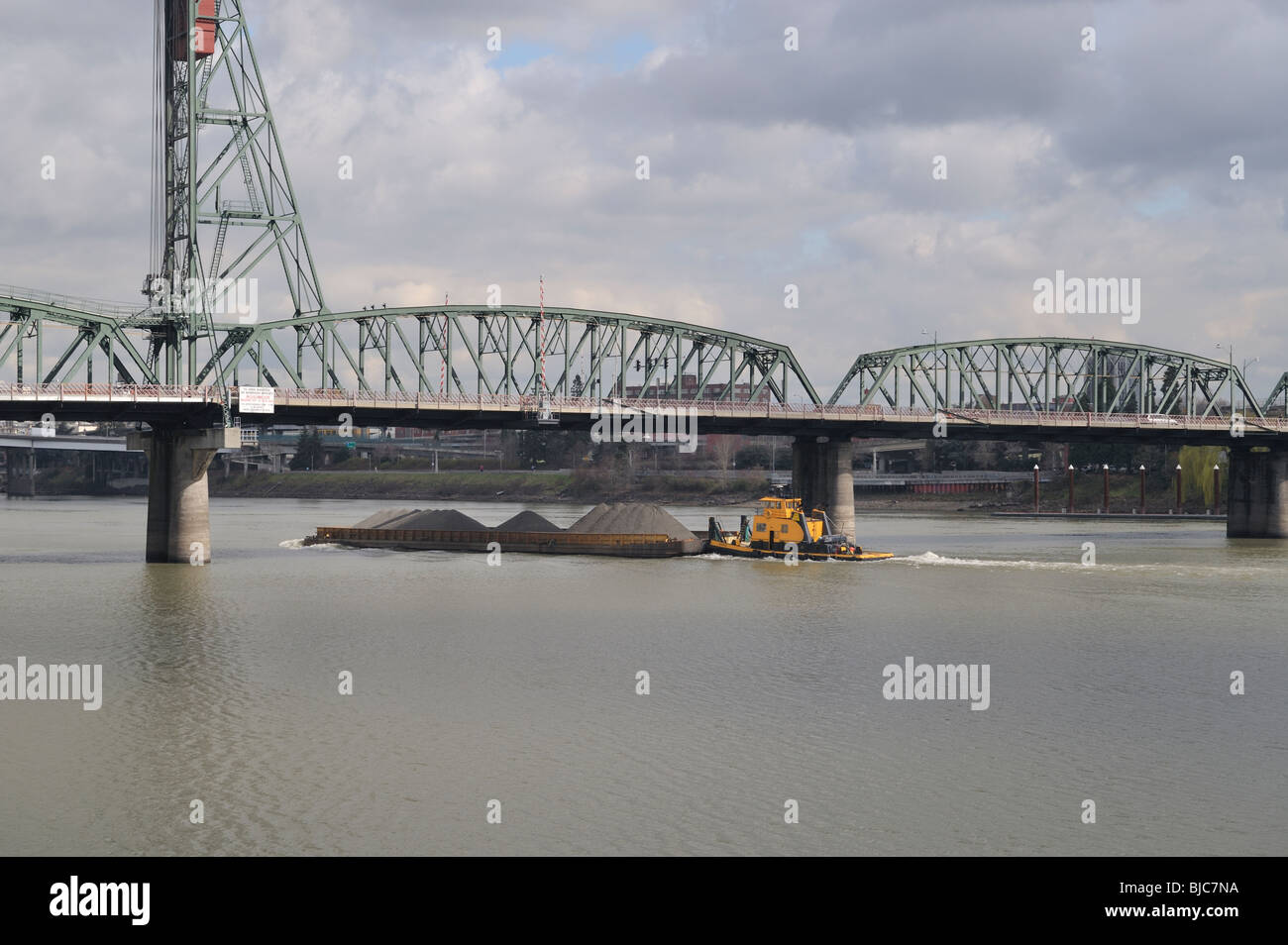 Un fiume chiatta e rimorchiatore a traino sul fiume Willamette passando sotto il ponte di Hawthorne, Portland, OR, Stati Uniti d'America 100304 34897 Foto Stock