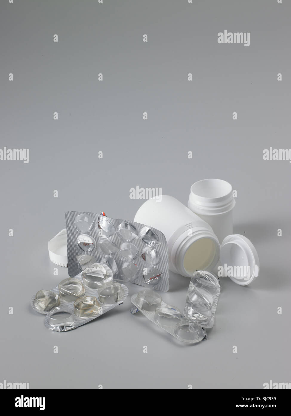 Rifiuti di imballaggio prodotti farmaceutici con plastica bianco flaconi portapillole shot in formato verticale e raccolto a tenuta Foto Stock
