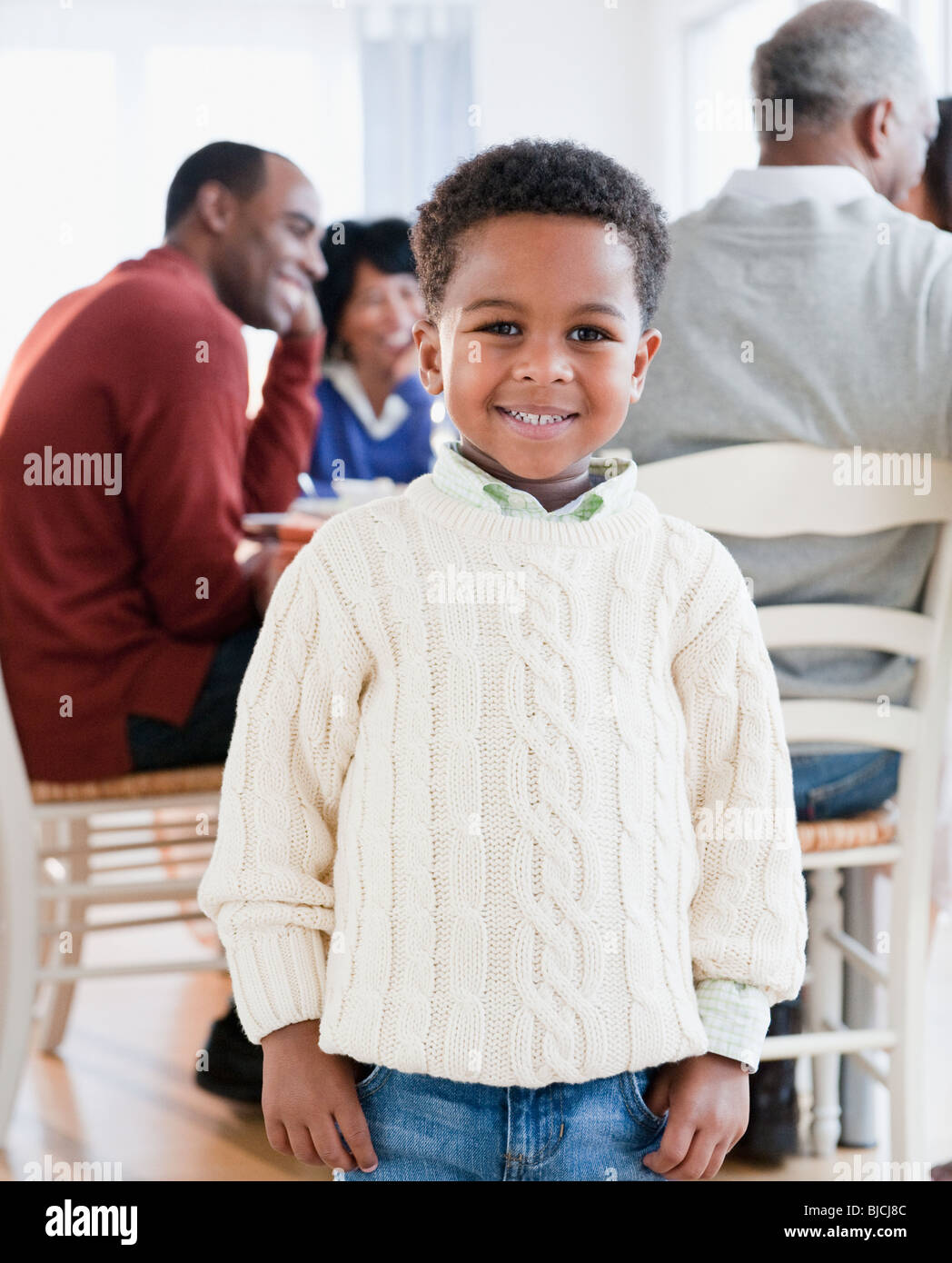 African American boy sorridente con la famiglia in background Foto Stock
