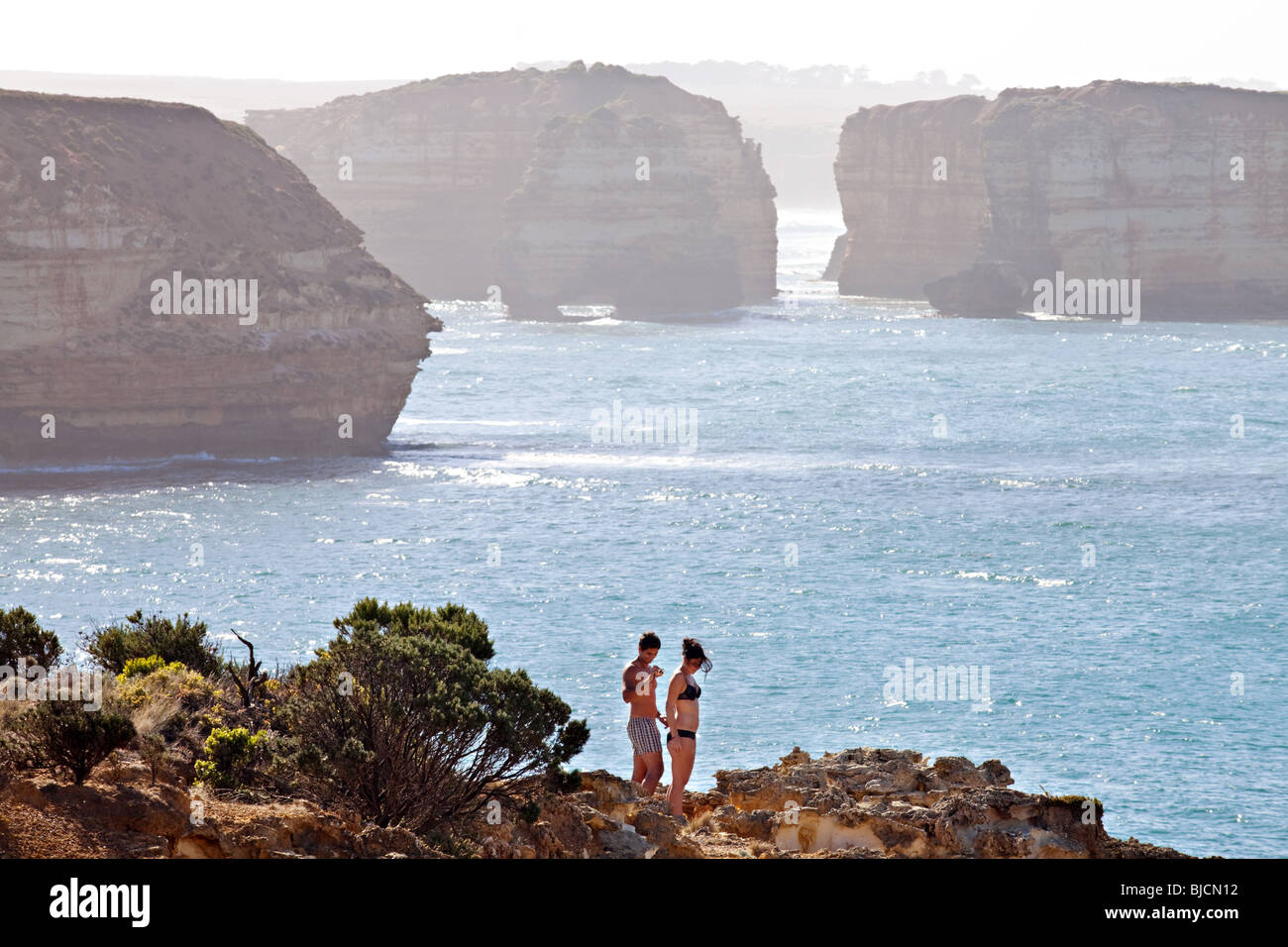 Un paio di divertirsi con la Great Ocean Road paesaggio scogliere in background, Sud Australia Foto Stock