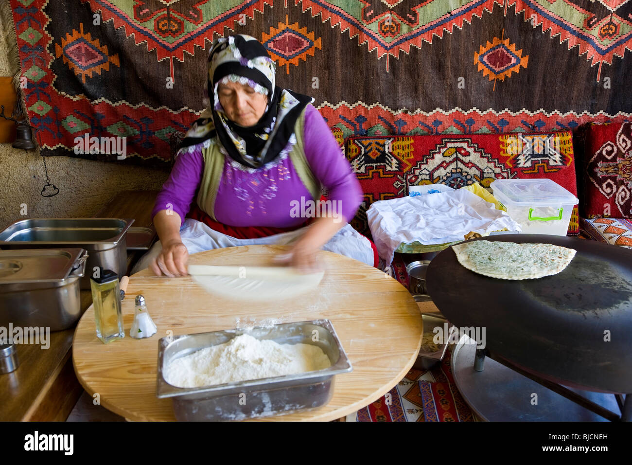 Donna fare Gozleme, sottile pane farcito con patate, spinaci, formaggio o carne tritata, Istanbul, Turchia Foto Stock