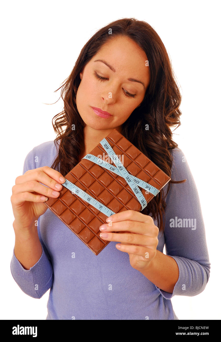 Donna che per la sua dieta e mangiare il cioccolato vietato Foto Stock