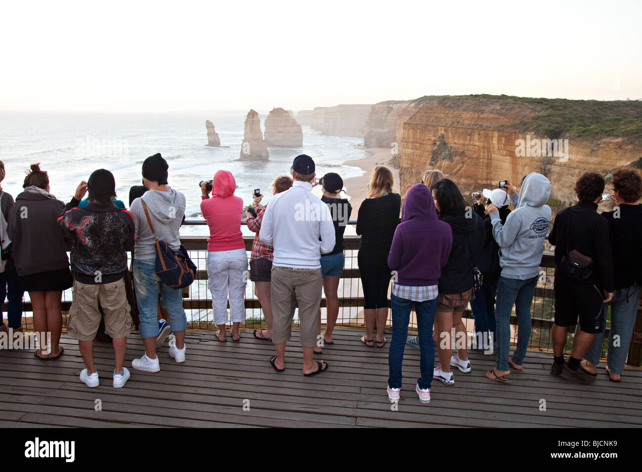 I turisti a guardare il tramonto , Dodici Apostoli, Parco Nazionale di Port Campbell, Victoria, Australia. Foto Stock