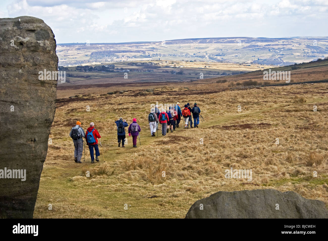 Walkers lasciando Bridestone roccia sopra Lydgate, Todmorden, Calder Valley ,South Pennines, West Yorkshire, Regno Unito Foto Stock