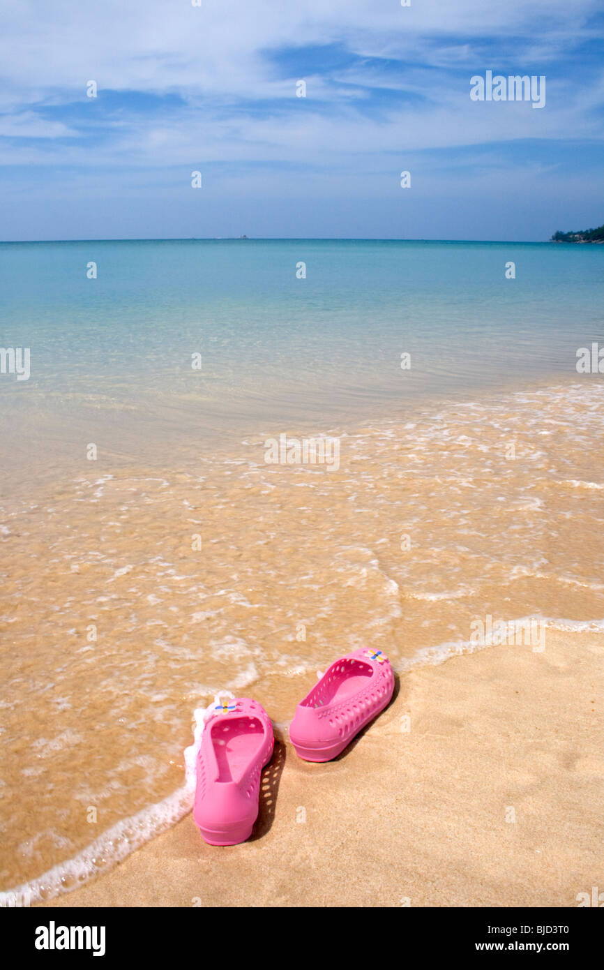 Spiaggia a piedi nudi, Thailandia, scarpe rosa a sinistra su di una spiaggia di sabbia di Bangtao Beach Phuket Thailandia Foto Stock