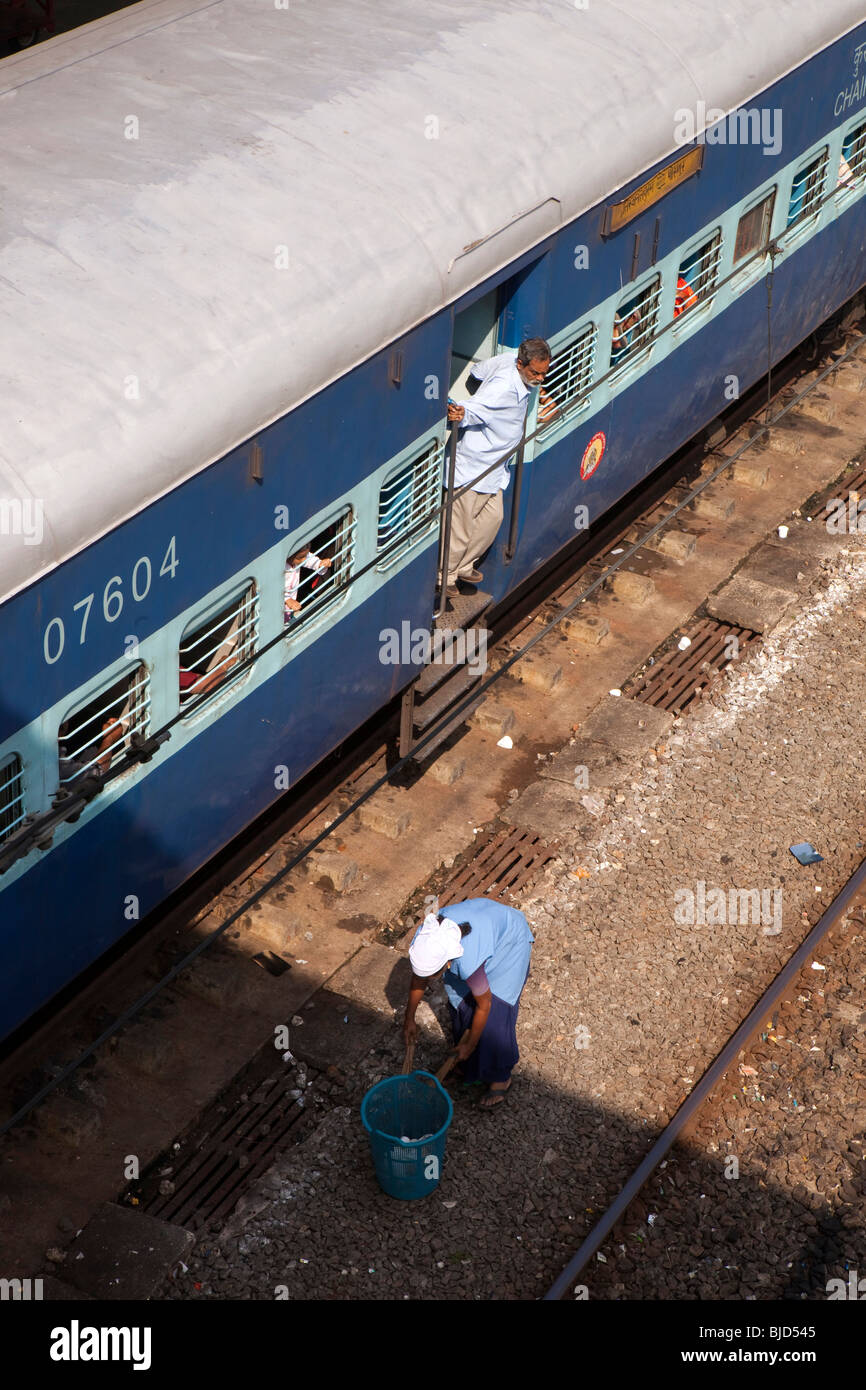 India Kerala, Kochi, Ernakulam Stazione ferroviaria uomo guarda la lettiera picker rimuovere rifiuti dalla linea Foto Stock