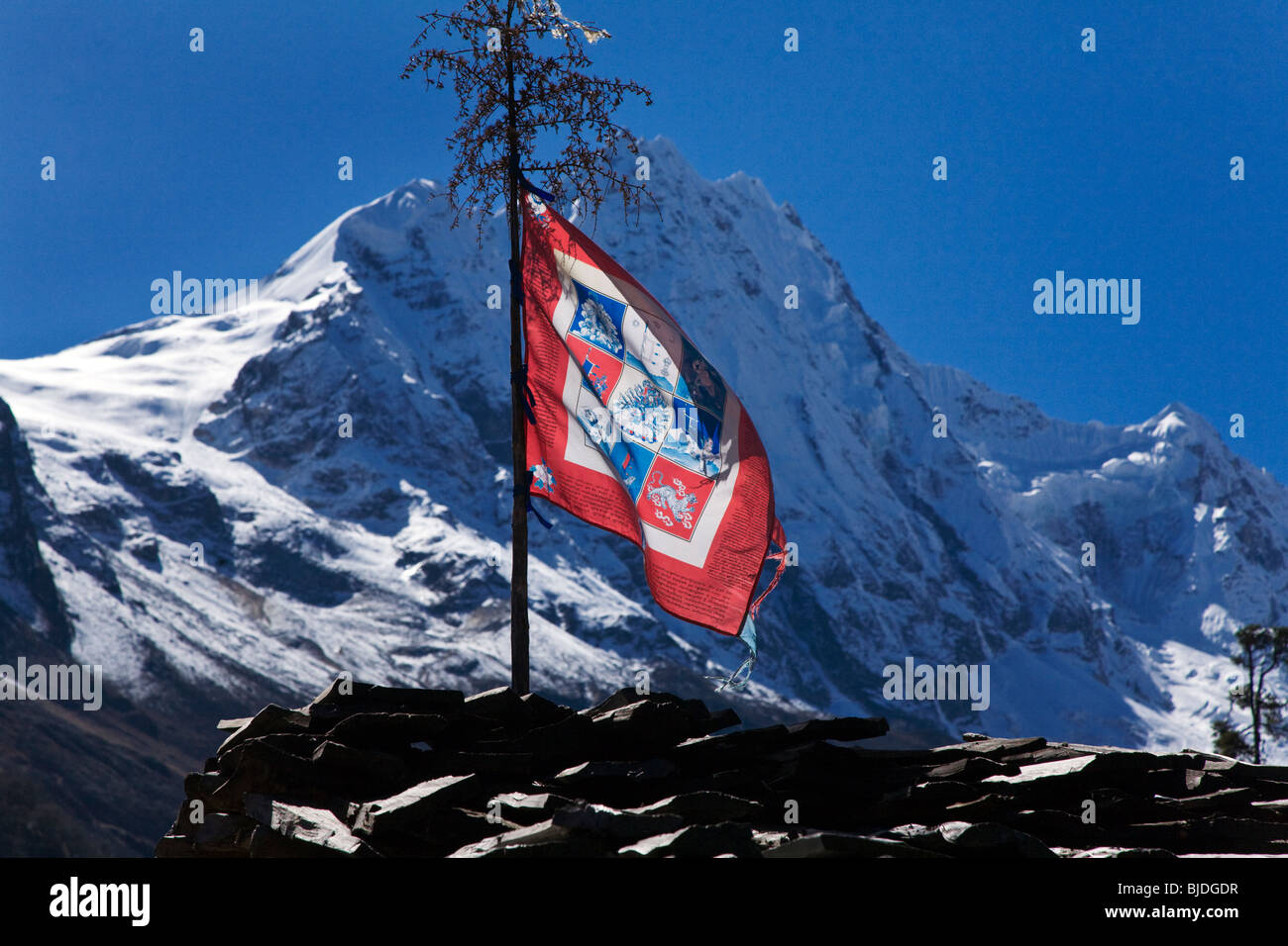 Una bandiera buddista in un tetto in SHYALA sul intorno il MANASLU TREK - REGIONE NUPRI, NEPAL Foto Stock
