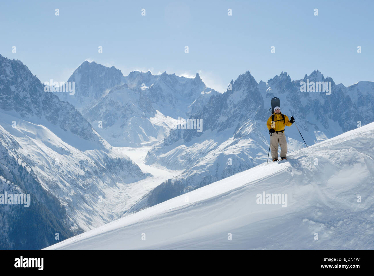 Snowboarder escursionismo con le racchette da neve portando la sua pensione in fuori-pista di terreno, Chamonix, Francia Foto Stock