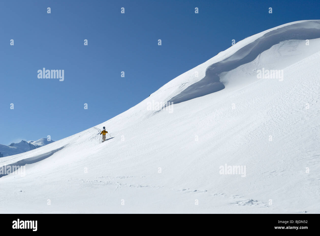 Snowboarder escursionismo con le racchette da neve portando la sua pensione in fuori-pista di terreno, Chamonix, Francia Foto Stock