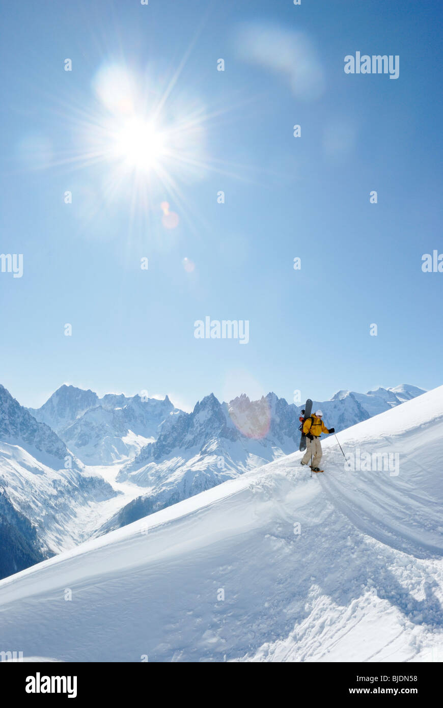 Snowboarder escursionismo con le racchette da neve portando la sua pensione in fuori-pista di terreno, Chamonix, Francia Foto Stock