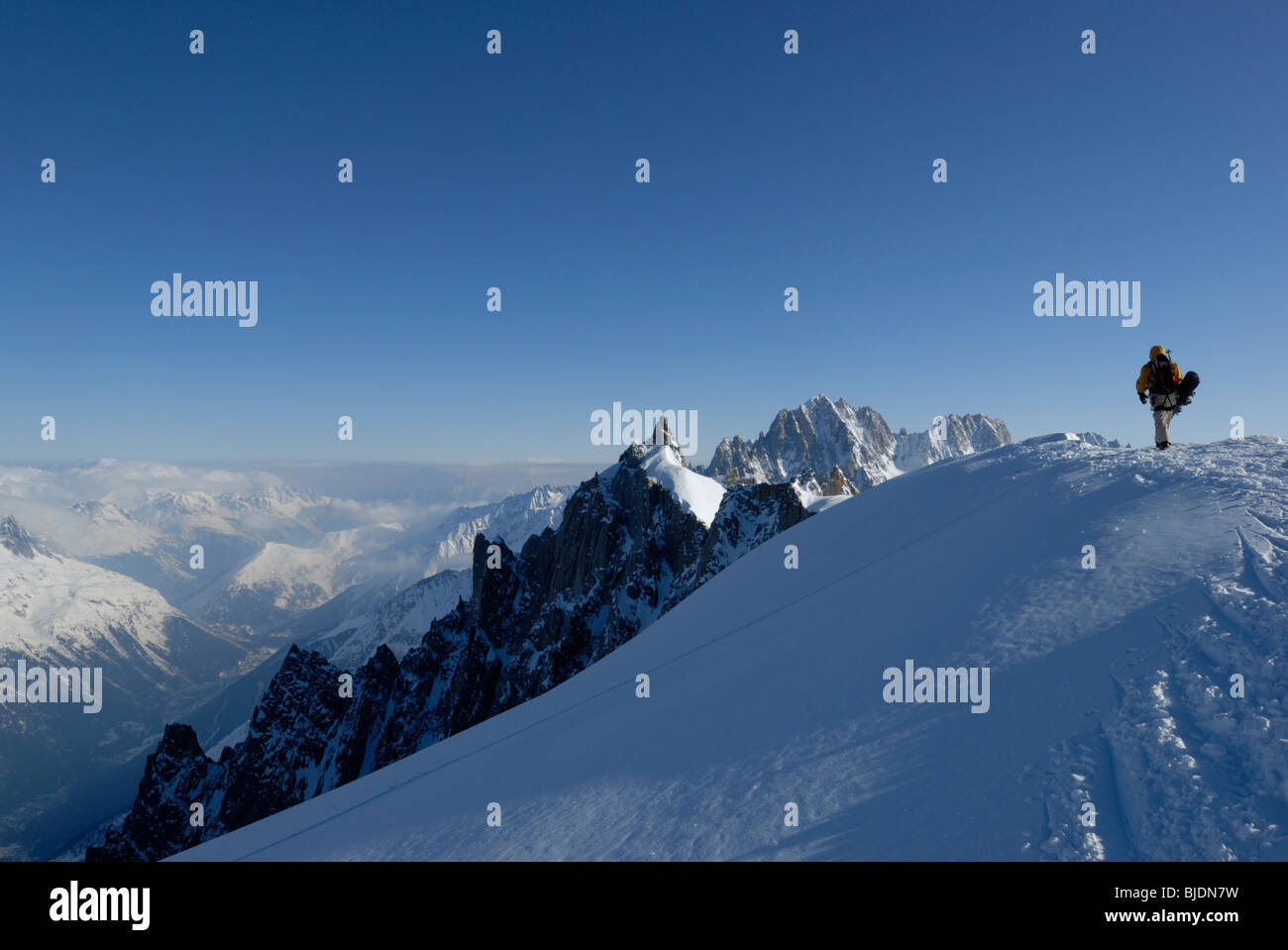 Snowboarder camminando sul monte alto cresta sopra Vallee Blanche sulla Aiguille du Midi, Chamonix, Francia Foto Stock