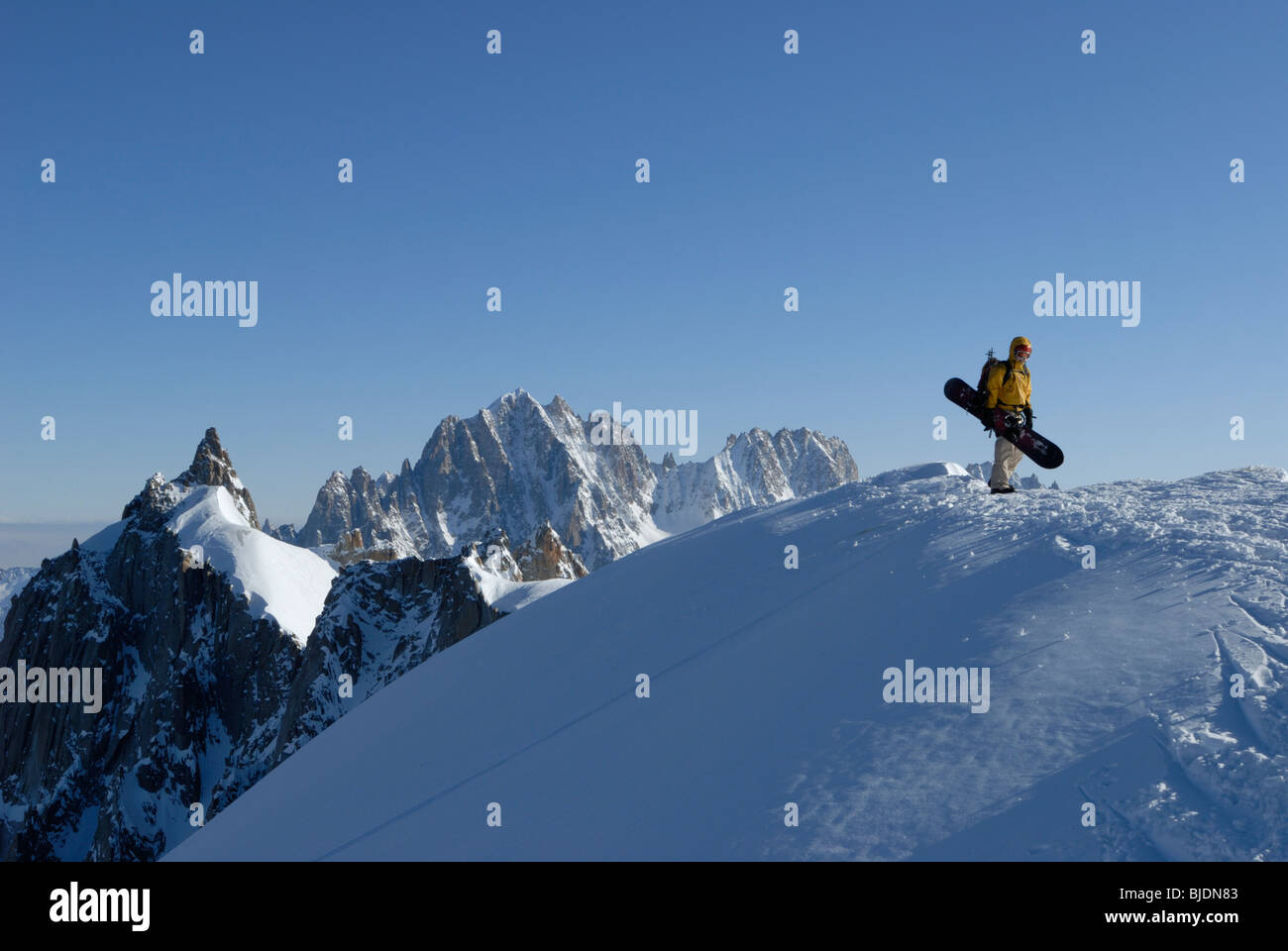 Snowboarder camminando sul monte alto cresta sopra Vallee Blanche sulla Aiguille du Midi, Chamonix, Francia Foto Stock