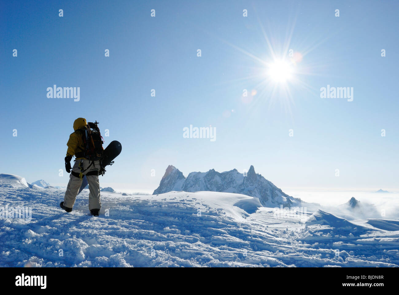 Snowboarder camminando sul monte alto cresta sopra Vallee Blanche sulla Aiguille du Midi, Chamonix, Francia Foto Stock