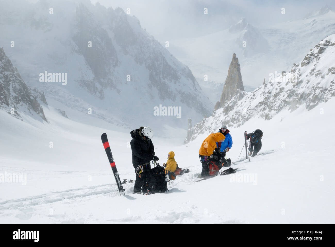Gruppo di sciatori rimozione di pelli di arrampicata e di preparazione per la discesa. Massiccio del Monte Bianco e la Vallee Blanche in distanza. Foto Stock
