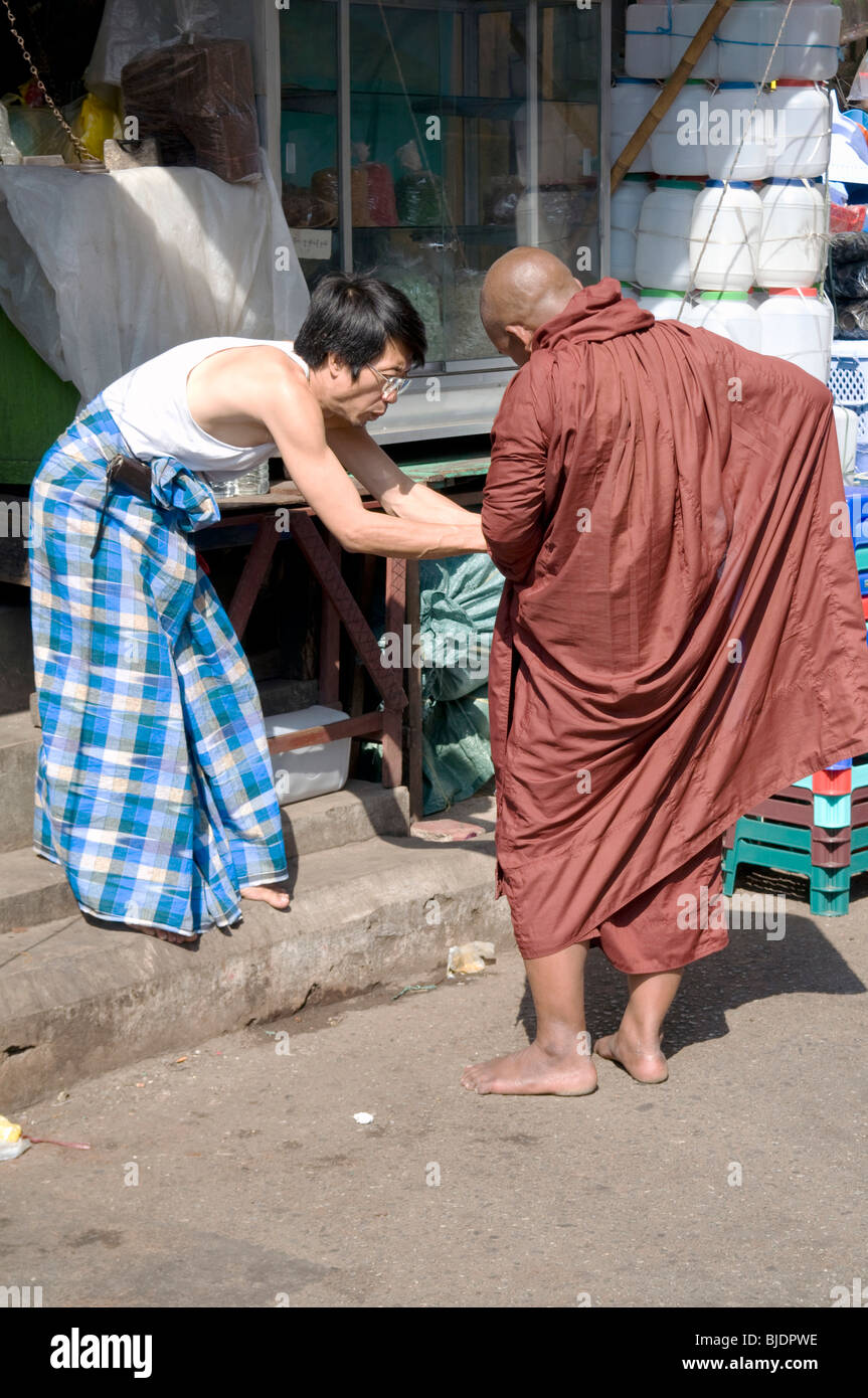 MYANMAR (Birmania) locale commerciante cinese e monaco buddista nella Chinatown di Yangon Foto © Julio Etchart Foto Stock