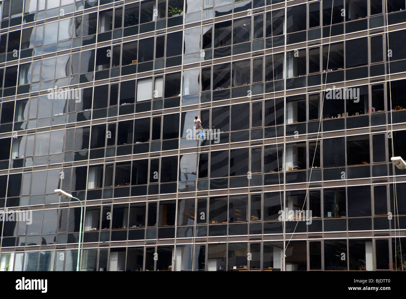 Uomo con calata funi per pulire le finestre di un edificio per uffici in microcenter financial district Capital Federal Buenos Aires Foto Stock