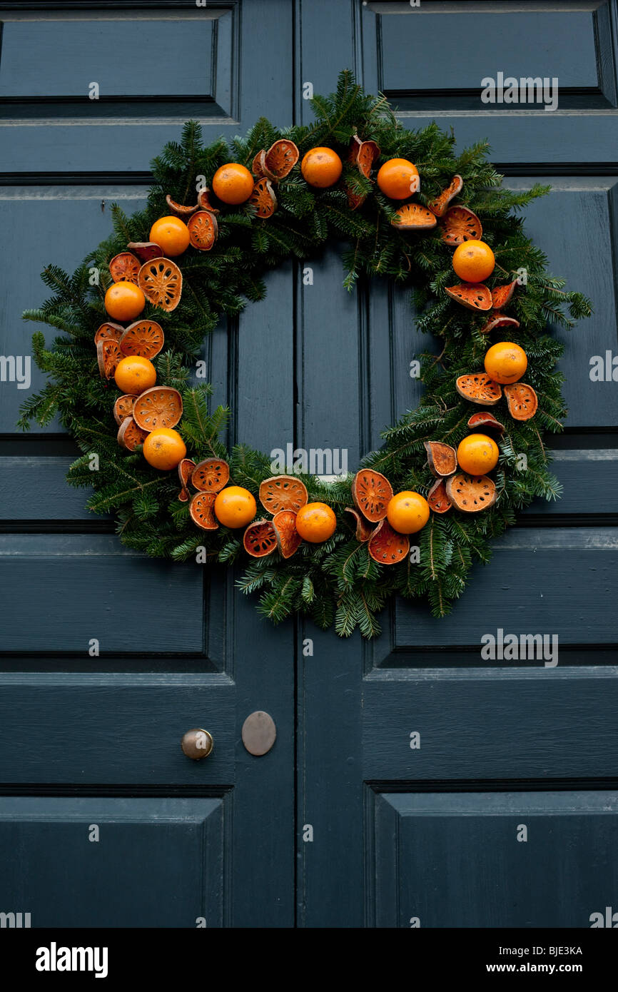 Un arancione ghirlanda di Natale Decorare una porta al Colonial Williamsburg nel tempo di Natale. Foto Stock