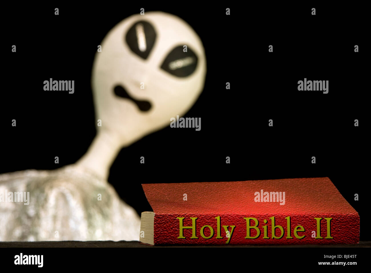 Un alieno con la Sacra Bibbia II. Può essere usato come un concetto per le questioni religiose, vita nell universo o l'origine dell'umanità. Foto Stock