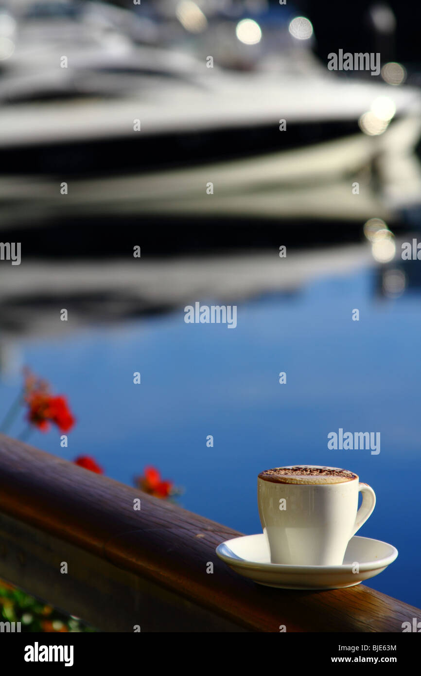 Una tazza da caffè con piattino collocato su un lato rampa che si affaccia su di una barca marina in Adelaide, Australia Foto Stock