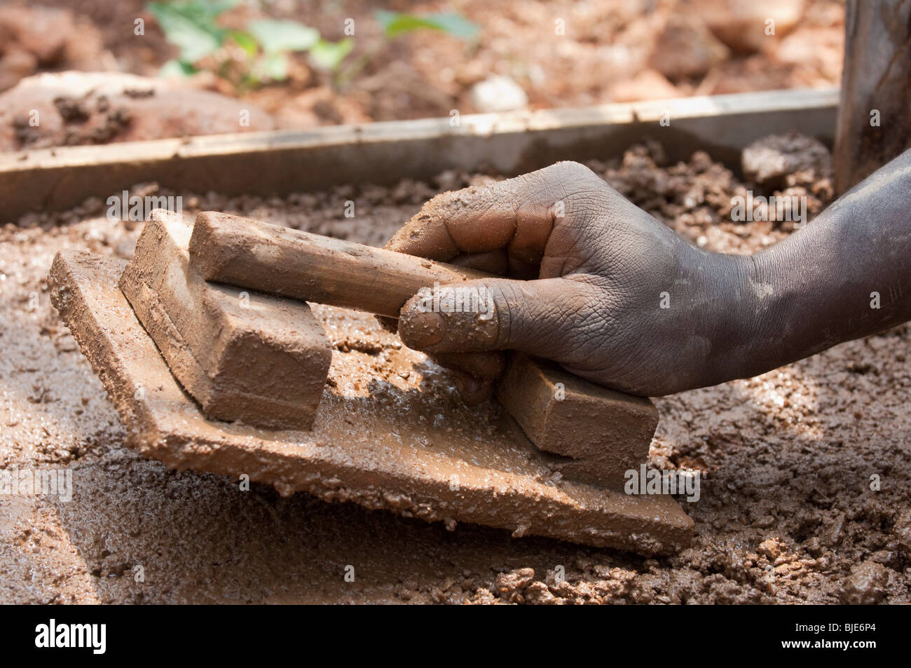 Posa del calcestruzzo per rendere il pavimento di una nuova stalla, Ruanda. Foto Stock