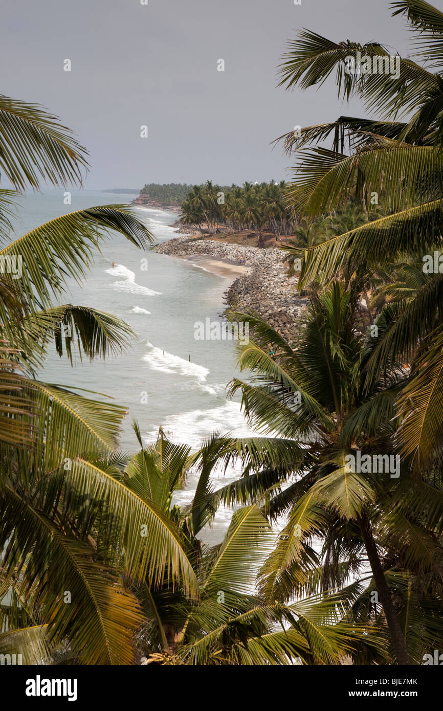 India Kerala, Varkala, coste visto attraverso gli alberi di cocco Foto Stock