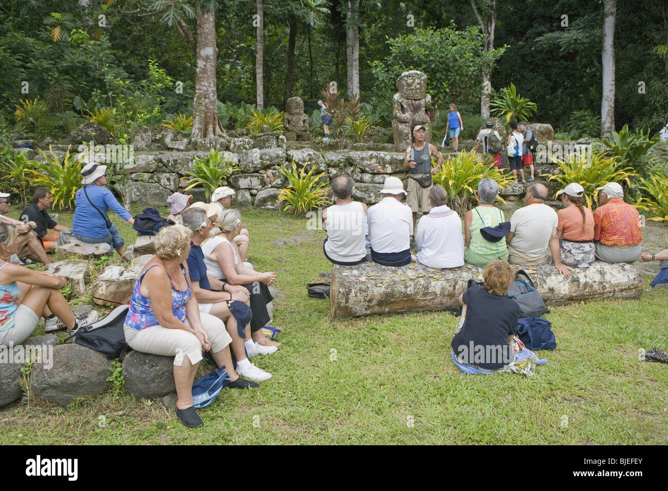 Gruppo di turisti vistiting polinesiano figure ancestrali, Puamau, Hiva Oa, Polinesia Francese Foto Stock