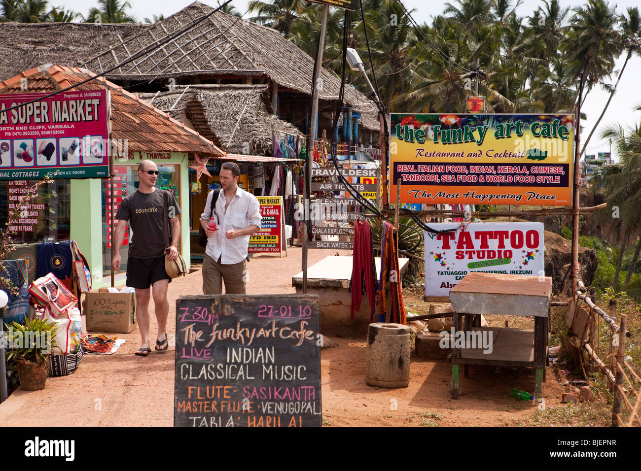 India Kerala, Varkala, i visitatori a piedi passato clifftop imprese turistiche Foto Stock